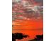 Stunning sunset view over the water, featuring vibrant orange and red hues, with docks visible along the shoreline at 6009 Sea Ranch Dr # 203, Hudson, FL 34667