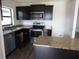 Modern kitchen features stainless steel appliances, dark cabinets, granite countertops and a breakfast bar at 1740 Chatham Green Cir, Ruskin, FL 33570