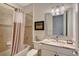 Well-lit bathroom with decorative shower curtain, tile and a large mirror over the vanity at 17109 Kenton Ter, Bradenton, FL 34202
