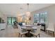 Open-concept dining room with a modern chandelier, large windows, and easy access to the living area at 17109 Kenton Ter, Bradenton, FL 34202