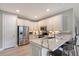Modern kitchen with white cabinets, stainless steel appliances, and a quartz breakfast bar at 17109 Kenton Ter, Bradenton, FL 34202