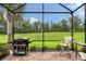 Screened-in lanai with grill, furniture and views of a beautiful backyard oasis and landscaping at 17109 Kenton Ter, Bradenton, FL 34202