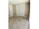 Bright bedroom featuring sliding closet doors and neutral color palette with tile flooring at 12215 Cobble Stone Dr, Hudson, FL 34667