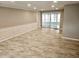 Spacious living room featuring tiled floors, neutral wall colors, crown molding, and sliding glass doors at 12215 Cobble Stone Dr, Hudson, FL 34667