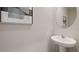Contemporary pedestal sink and round mirror offer a clean and modern look at 5108 Captain Davis Dr, Wimauma, FL 33598
