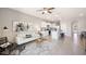 Open-concept living room and kitchen area with modern tile flooring, white cabinets, and stainless steel appliances at 5108 Captain Davis Dr, Wimauma, FL 33598
