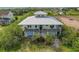 Elevated view of a two-story house with a metal roof, a large deck and water views at 935 Bayshore Dr, Palmetto, FL 34221