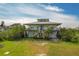 Two-story yellow house with a large yard and attached garage at 935 Bayshore Dr, Palmetto, FL 34221