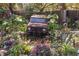 Unique pond feature with rusted vehicle art piece and lush landscaping at 3736 Lado Dr, Wesley Chapel, FL 33543