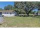Spacious backyard with grassy area, mature trees, and partial view of home at 3736 Lado Dr, Wesley Chapel, FL 33543