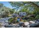 Outdoor patio with pond feature, lush landscaping, and seating area at 3736 Lado Dr, Wesley Chapel, FL 33543
