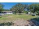 Large grassy backyard with mature trees and partial home view at 3736 Lado Dr, Wesley Chapel, FL 33543