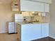 Galley-style kitchen with white cabinets and appliances at 4329 Tahitian Gardens Cir # B, Holiday, FL 34691
