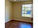 Cozy bedroom with laminate flooring and a large window offering natural light and street views at 4329 Tahitian Gardens Cir # B, Holiday, FL 34691