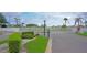Gated community entrance with white fencing, manicured landscaping, and a clearly marked stop sign at 4329 Tahitian Gardens Cir # B, Holiday, FL 34691