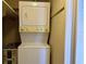 Laundry area with a stacked washer and dryer unit next to a water heater at 4329 Tahitian Gardens Cir # B, Holiday, FL 34691