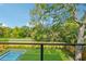 View from the balcony of a private yard with landscaping on a sunny day with blue skies and white clouds at 1630 Douglas Ave, Dunedin, FL 34698