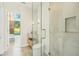 Modern bathroom featuring marble vanity, glass-enclosed shower, and elegant fixtures, with a view to the backyard at 1630 Douglas Ave, Dunedin, FL 34698