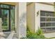 Elegant home entrance showcases stone accents, glass door, and lush landscaping details at 1630 Douglas Ave, Dunedin, FL 34698