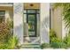 Modern home entrance featuring stone pillars, glass door, and landscaped walkway at 1630 Douglas Ave, Dunedin, FL 34698