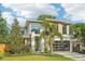 Modern home boasting clean lines, large windows, lush landscaping, and a well-maintained lawn at 1630 Douglas Ave, Dunedin, FL 34698