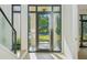 Modern home entryway featuring a glass front door, wood floors, and neutral color palette, offering a bright and welcoming entrance at 1630 Douglas Ave, Dunedin, FL 34698