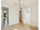 Bright hallway with hardwood floors, modern lighting fixture, and open doorways leading to other rooms of the house at 1630 Douglas Ave, Dunedin, FL 34698