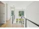 Bright hallway boasts hardwood floors and glass railing overlooking floor-to-ceiling windows at 1630 Douglas Ave, Dunedin, FL 34698