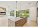 Modern kitchen with marble island, stainless sink and hardware, floor-to-ceiling windows, and modern lighting at 1630 Douglas Ave, Dunedin, FL 34698