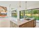 Bright, open kitchen with marble island, modern fixtures, and large windows overlooking the landscaped backyard at 1630 Douglas Ave, Dunedin, FL 34698