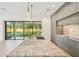 Modern kitchen with marble island, stainless sink and hardware, gray cabinets and floor-to-ceiling windows at 1630 Douglas Ave, Dunedin, FL 34698