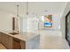 Bright, open kitchen with stainless sink, marble island, modern lighting, and views into the spacious living room at 1630 Douglas Ave, Dunedin, FL 34698