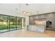 Modern kitchen featuring an oversized island, stainless steel appliances, and a large window overlooking the yard at 1630 Douglas Ave, Dunedin, FL 34698