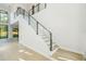 Bright entryway featuring a modern staircase with glass railings and hardwood floors at 1630 Douglas Ave, Dunedin, FL 34698