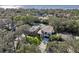 A modern house is shown in an aerial view, with water in the background at 1630 Douglas Ave, Dunedin, FL 34698