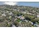 Aerial view of a house near the water with surrounding houses and trees at 1630 Douglas Ave, Dunedin, FL 34698