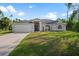Newly built home with gray exterior, two-car garage, and well-manicured lawn at 2510 Sheila Ln, North Port, FL 34286
