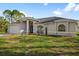 Newly built home with gray exterior, two-car garage, and well-manicured lawn at 2510 Sheila Ln, North Port, FL 34286