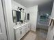 Bathroom with double vanity, large mirror, and white cabinets at 2510 Sheila Ln, North Port, FL 34286