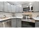 Modern kitchen with stainless steel appliances and gray cabinets at 8901 Blind Pass Rd # 228, St Pete Beach, FL 33706