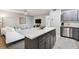 Open concept kitchen and living room with modern island and white sofa at 8901 Blind Pass Rd # 228, St Pete Beach, FL 33706