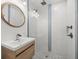 Modern bathroom featuring glass shower with dual heads and a stylish wooden vanity with a vessel sink at 15810 2Nd E St, Redington Beach, FL 33708