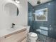 Modern bathroom features blue tiled shower with glass door and floating vanity at 15810 2Nd E St, Redington Beach, FL 33708