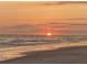 The sun rises over the ocean while reflecting onto the sandy beach and the shallow waves at 15810 2Nd E St, Redington Beach, FL 33708