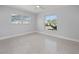 Simple bedroom with two windows and terrazzo floors with a fan overhead at 15810 2Nd E St, Redington Beach, FL 33708