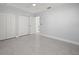 Neutral-toned bedroom with 3 closet doors, ceiling fan and durable terrazzo floors at 15810 2Nd E St, Redington Beach, FL 33708