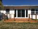 Backyard deck with wood railings overlooks the lawn and the sliding glass doors let light into the home at 15810 2Nd E St, Redington Beach, FL 33708