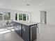 Open kitchen featuring a large island with a wine cooler, a dining table, and terrazzo floors at 15810 2Nd E St, Redington Beach, FL 33708