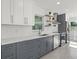 Updated kitchen with stainless steel appliances, white cabinets, and grey lower cabinets at 15810 2Nd E St, Redington Beach, FL 33708