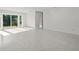 Bright and airy living room with a sliding glass door, terrazzo flooring, and neutral decor at 15810 2Nd E St, Redington Beach, FL 33708